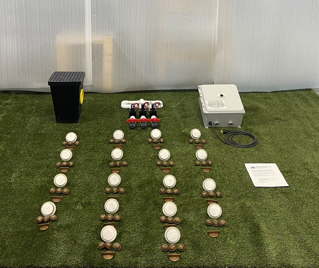 Components included with a 12-nozzle freshwater dog water park kit, including spray nozzles, manifold, control box, and drain box