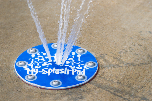 Blue circular geyser spray feature installed in concrete and spraying water upward